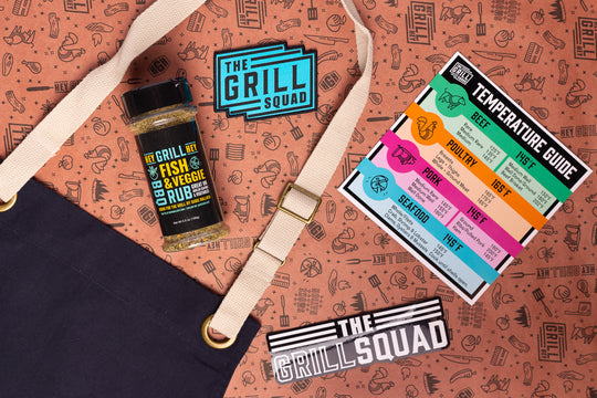 A bottle of BBQ Rub, a Grill Squad patch, a magnet temperature guide, a Grill Squad sticker, and an apron sit on butcher paper.