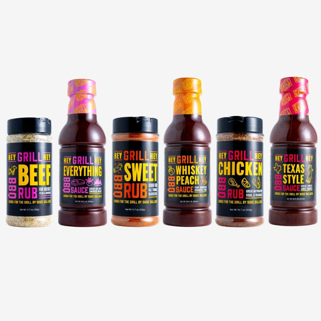 A bottle of Beef Rub, Everything Sauce, Sweet Rub, Whiskey Peach Sauce, Chicken Rub, and Texas Style Sauce sit on a white background.