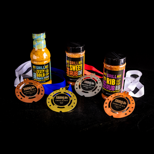 Zesty Gold sauce sitting next to a 3rd place NBBAQ award. Sweet Rub sitting next to a second place NBBAQ award. and Rib Rub sitting next to a third place NBBQA award. These items are on a black background. 