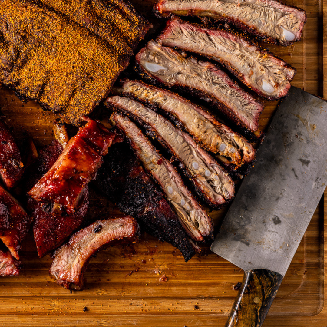 Overhead shot of smoked and sliced ribs on a wooden cutting board.