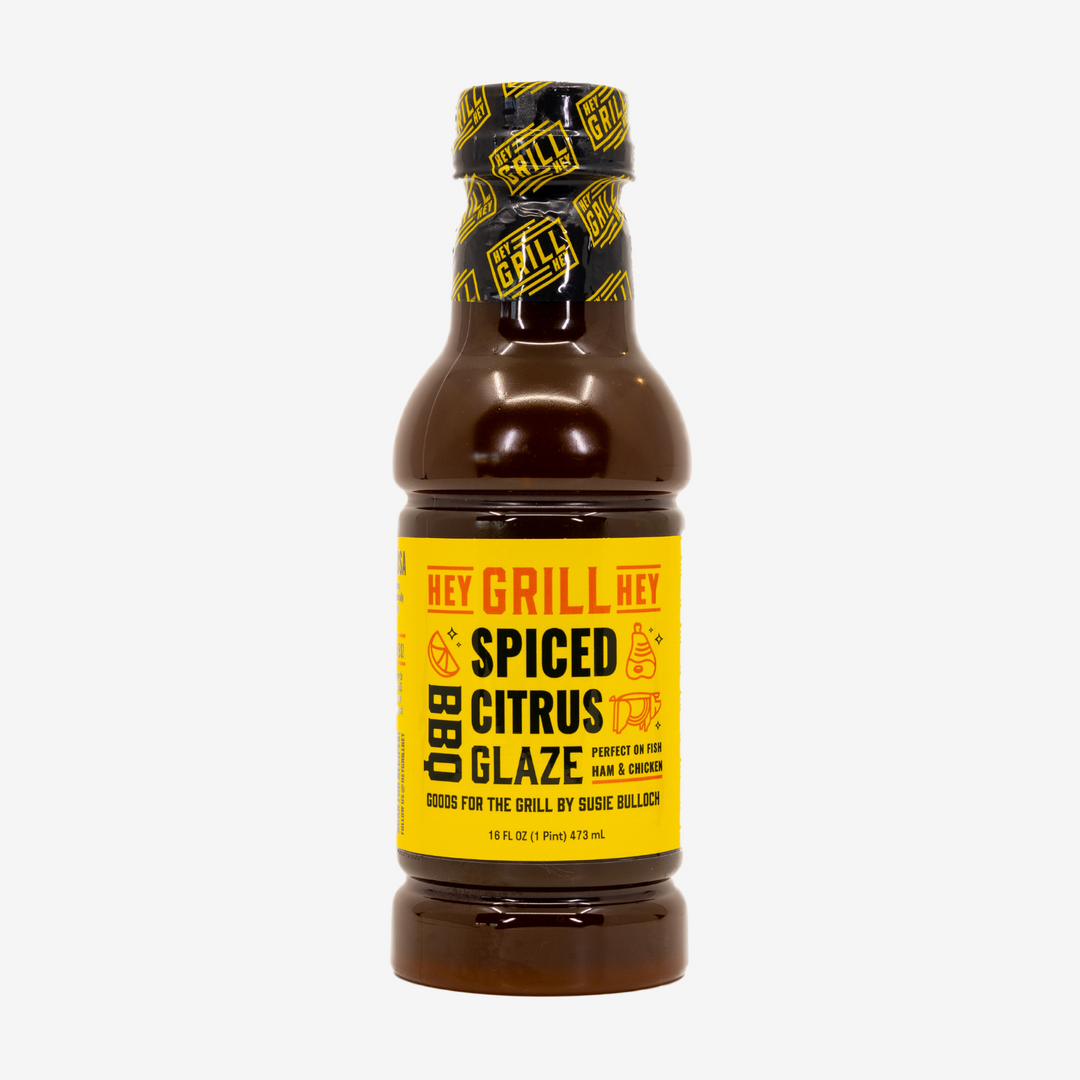 A bottle of Spiced Citrus BBQ Glaze over on a white background. 